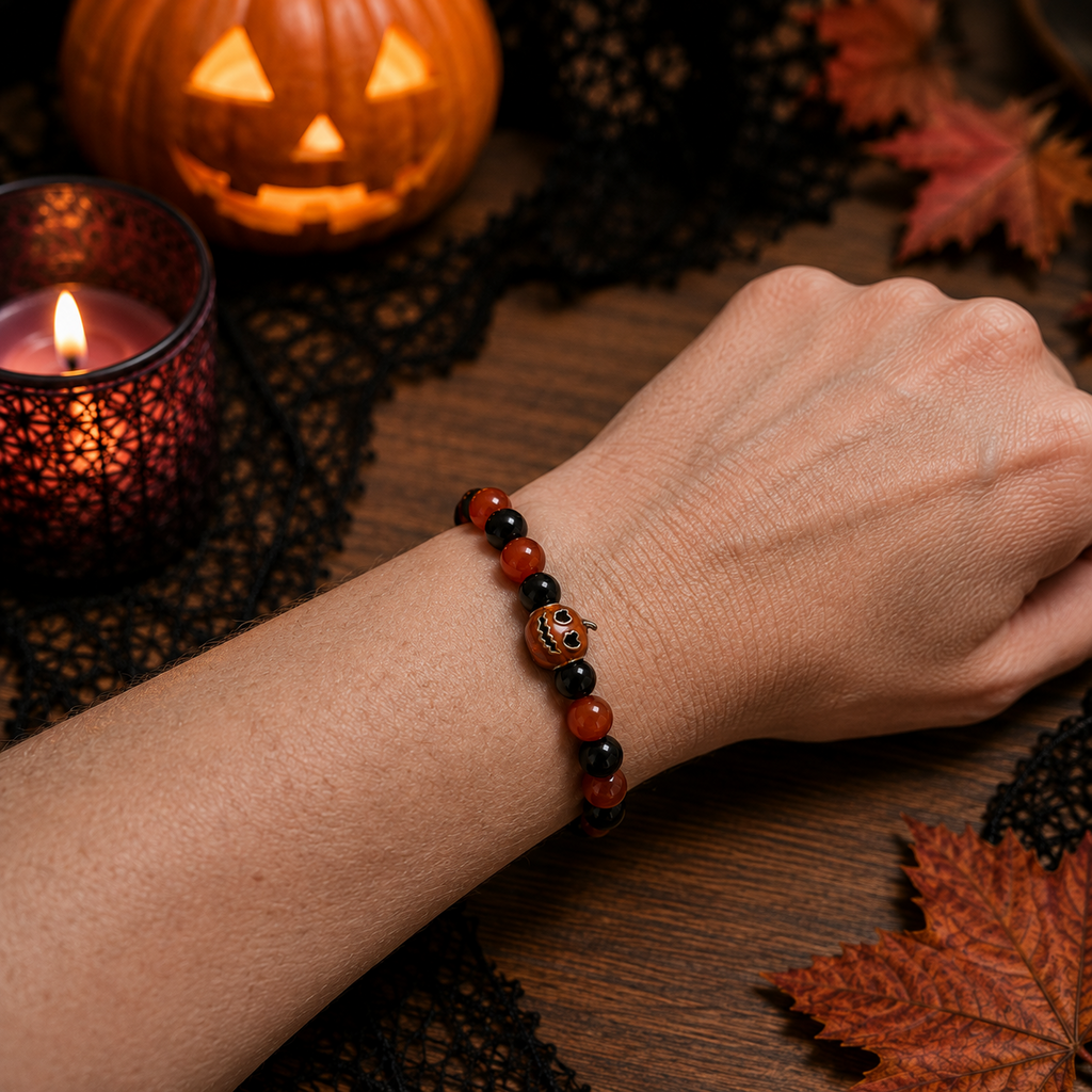 Orange and black Halloween pumpkin bracelet worn on a wrist