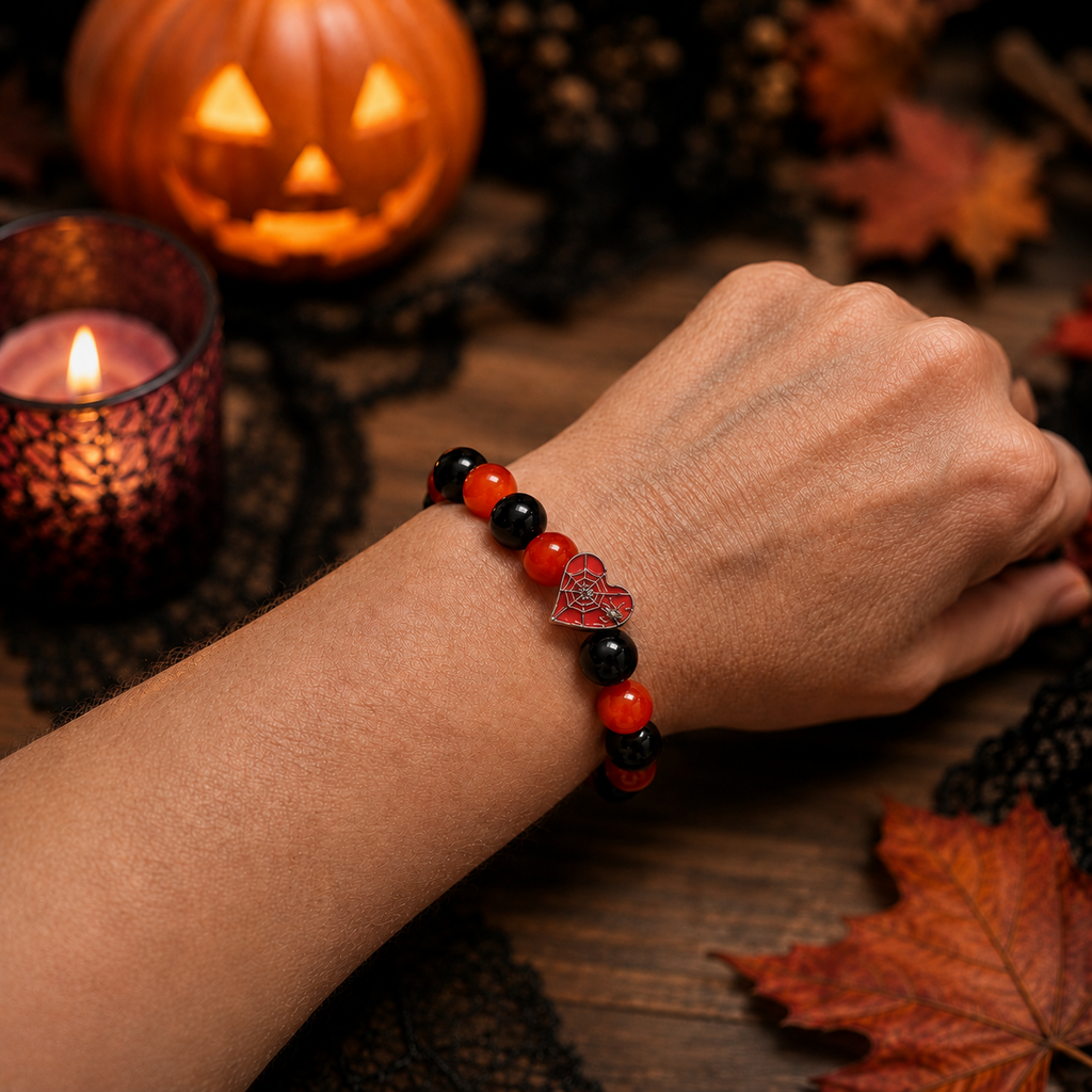 Red and black spiderweb heart Halloween bracelet worn on a wrist