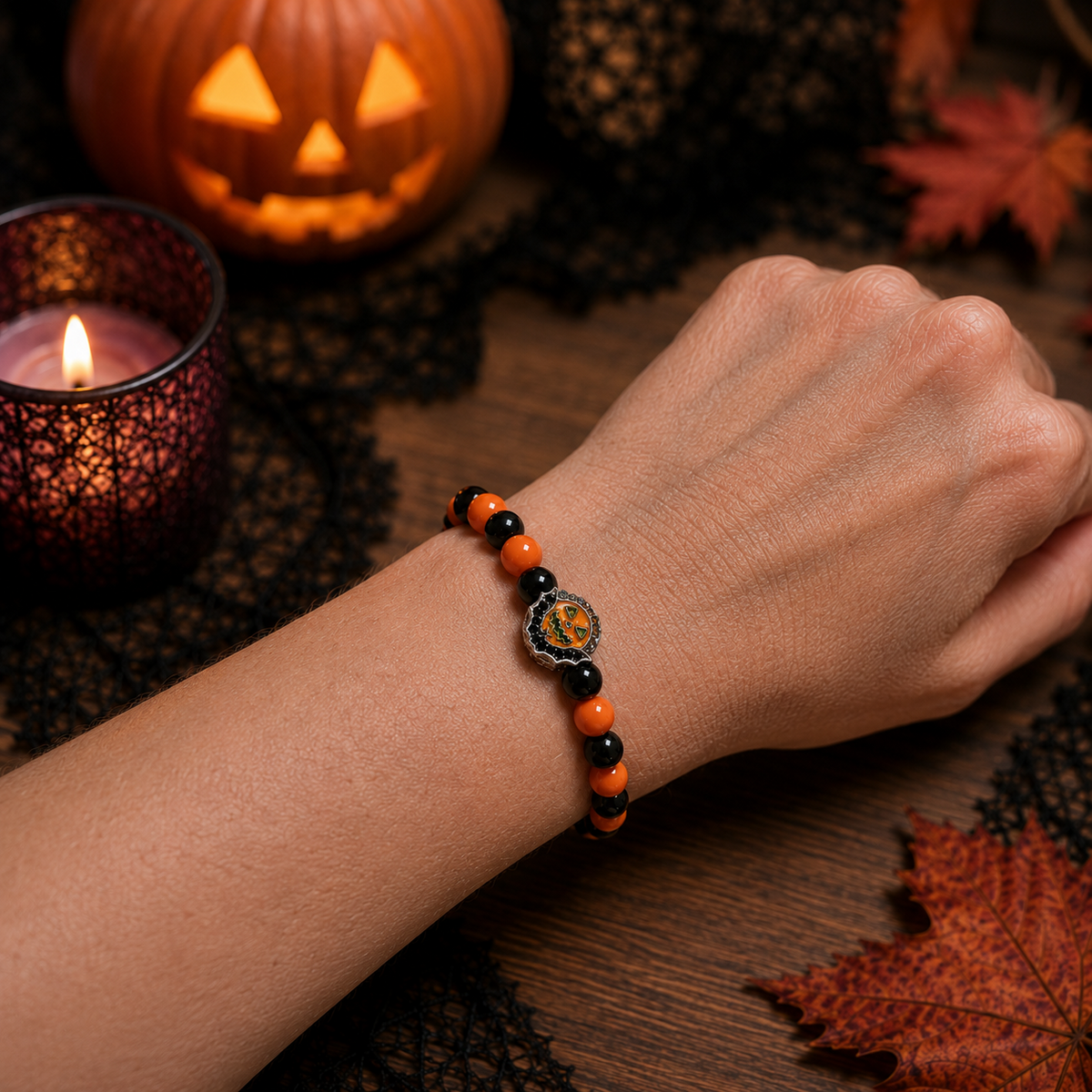 Orange and black jack-o'-lantern Halloween bracelet worn on a wrist