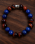 Men's Red Tiger Eye and Lapis Lazuli 10mm beaded bracelet with silver-tone centerpiece on dark wood background